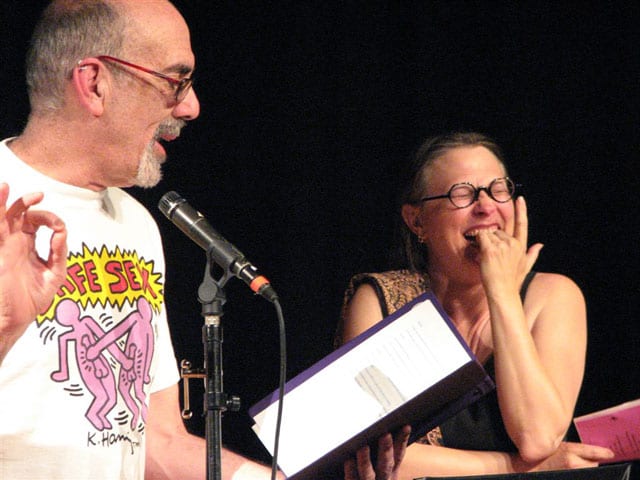(Left) Balding man with glasses wearing Keith Haring shirt (Right) Laughing woman with glasses