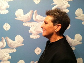 photo of Tirza Latimer in front of wallpaper of doves